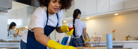 Professional cleaner cleaning a table at a house